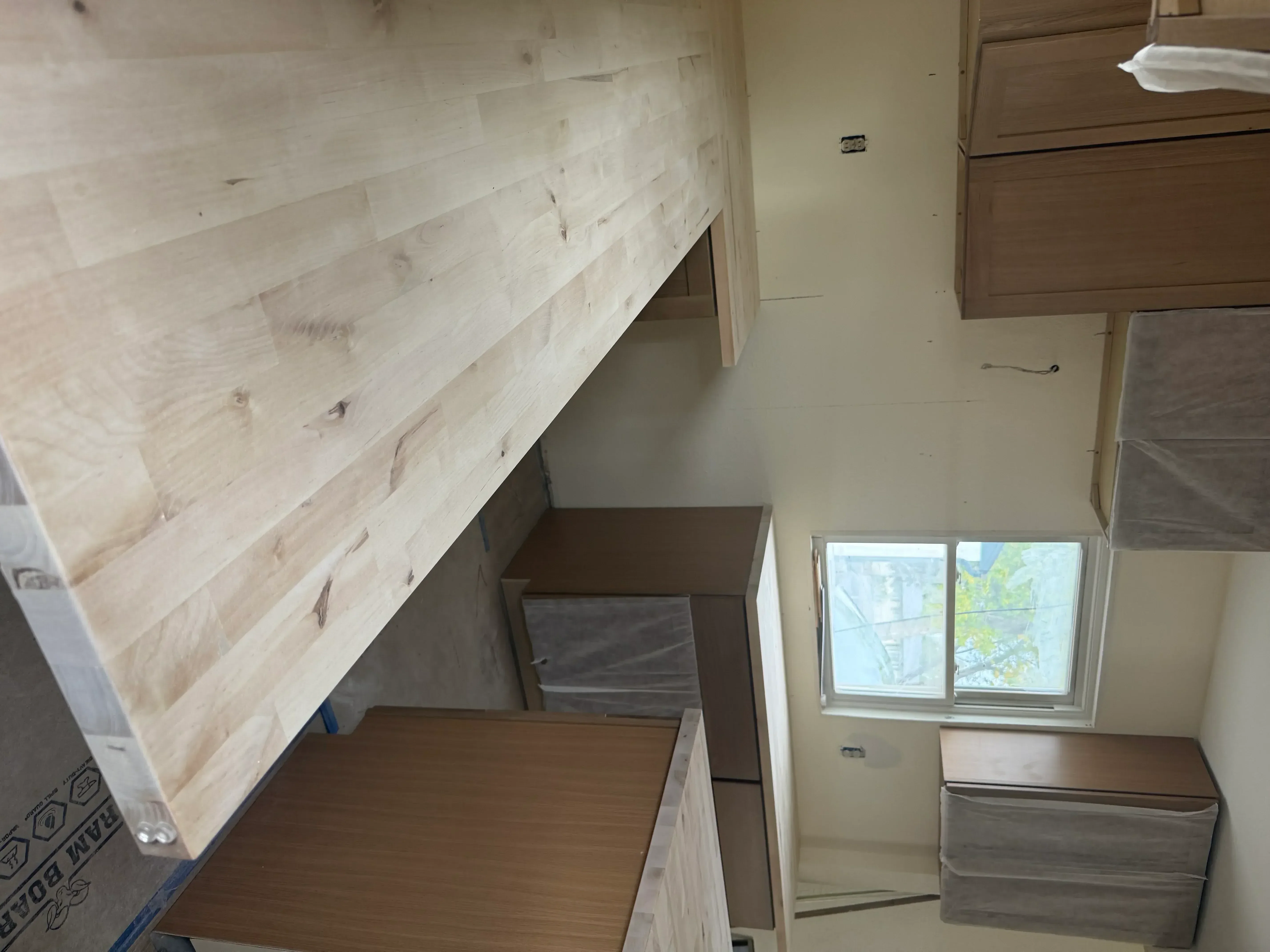 Kitchen remodel with light wood flooring, mixed wood cabinetry, and updated ceiling materials
