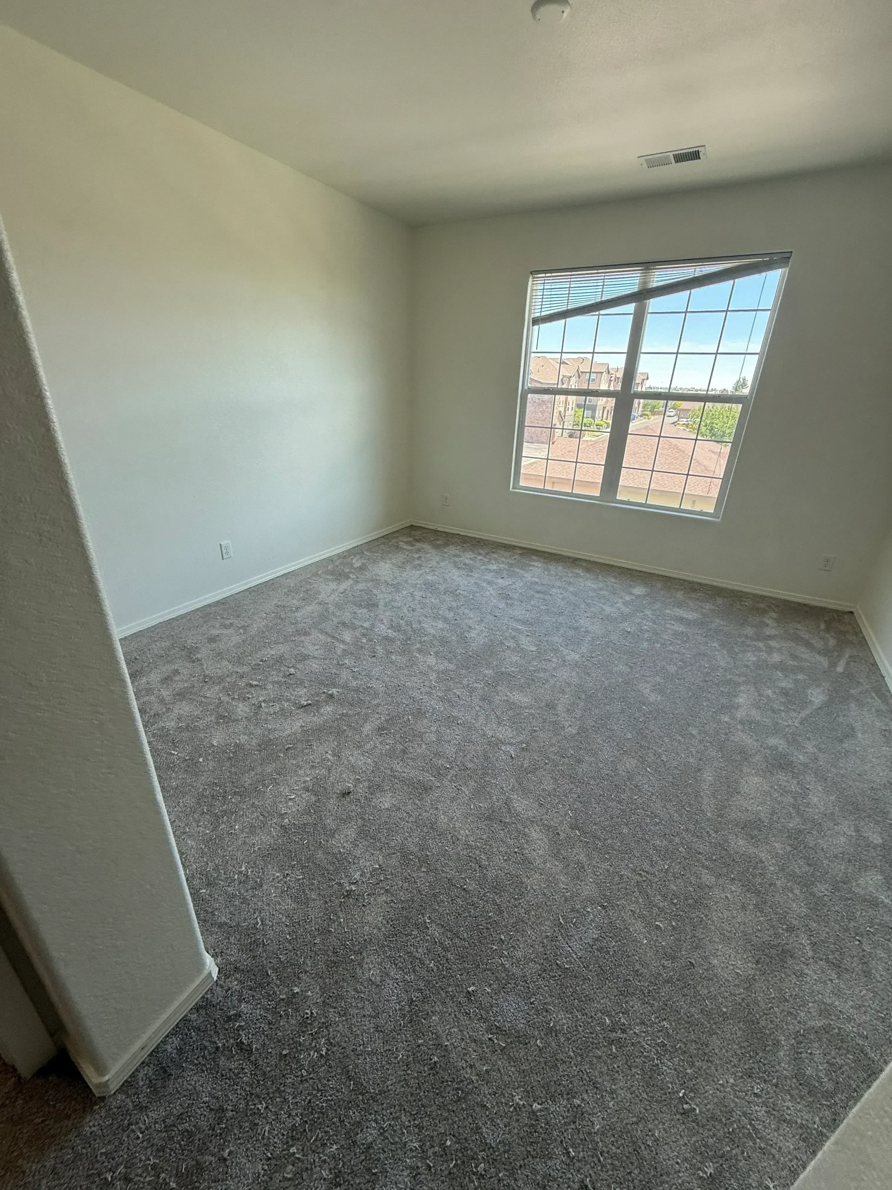 Gray tile flooring with painted drywall walls and gridded window in finished interior space