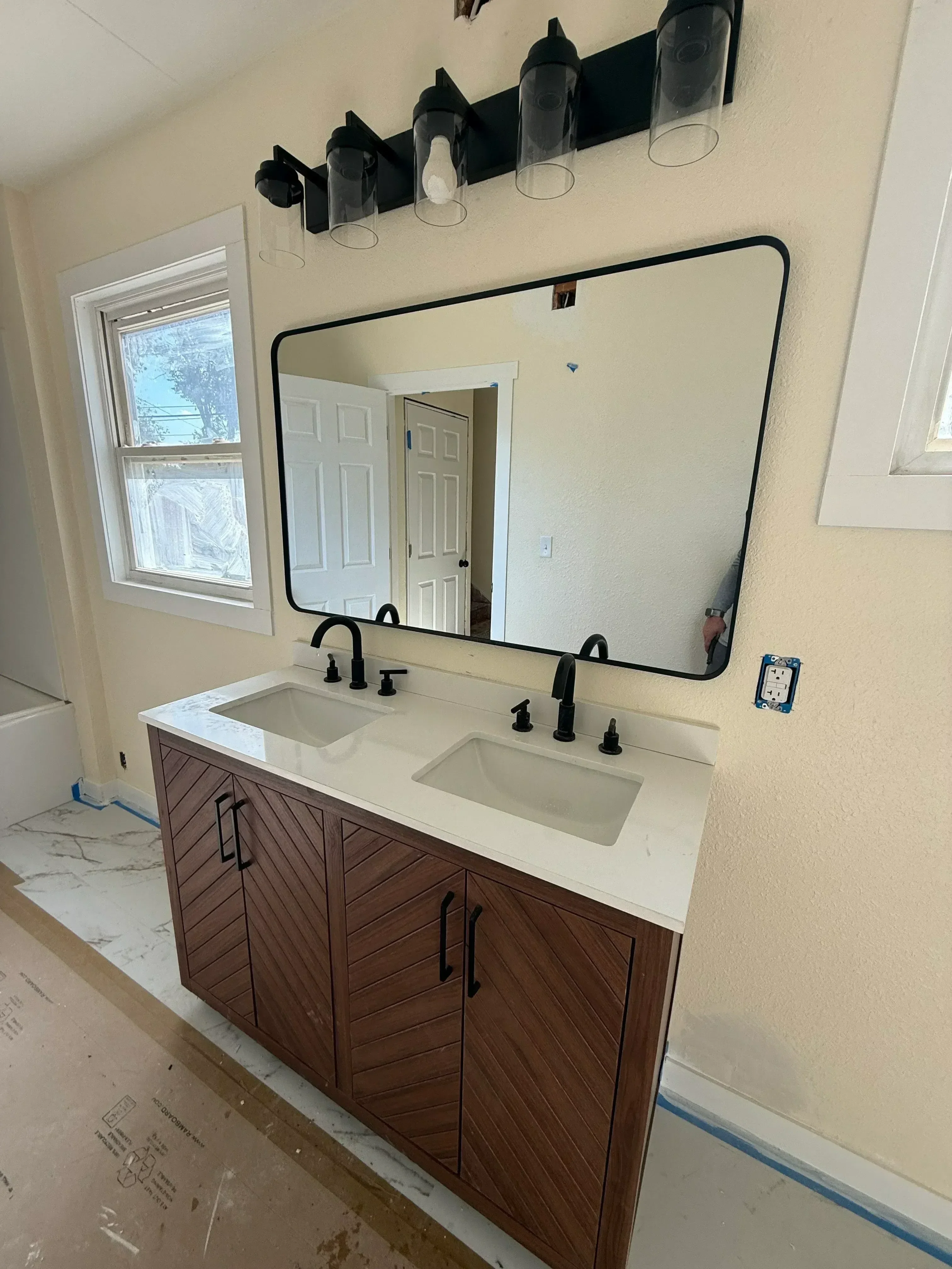 Custom dark wood kitchen cabinets with black handles, white subway tile backsplash, and new electrical outlets