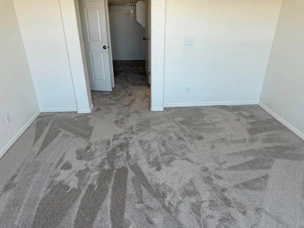 Gray patterned carpet installation in residential interior with white walls and trim