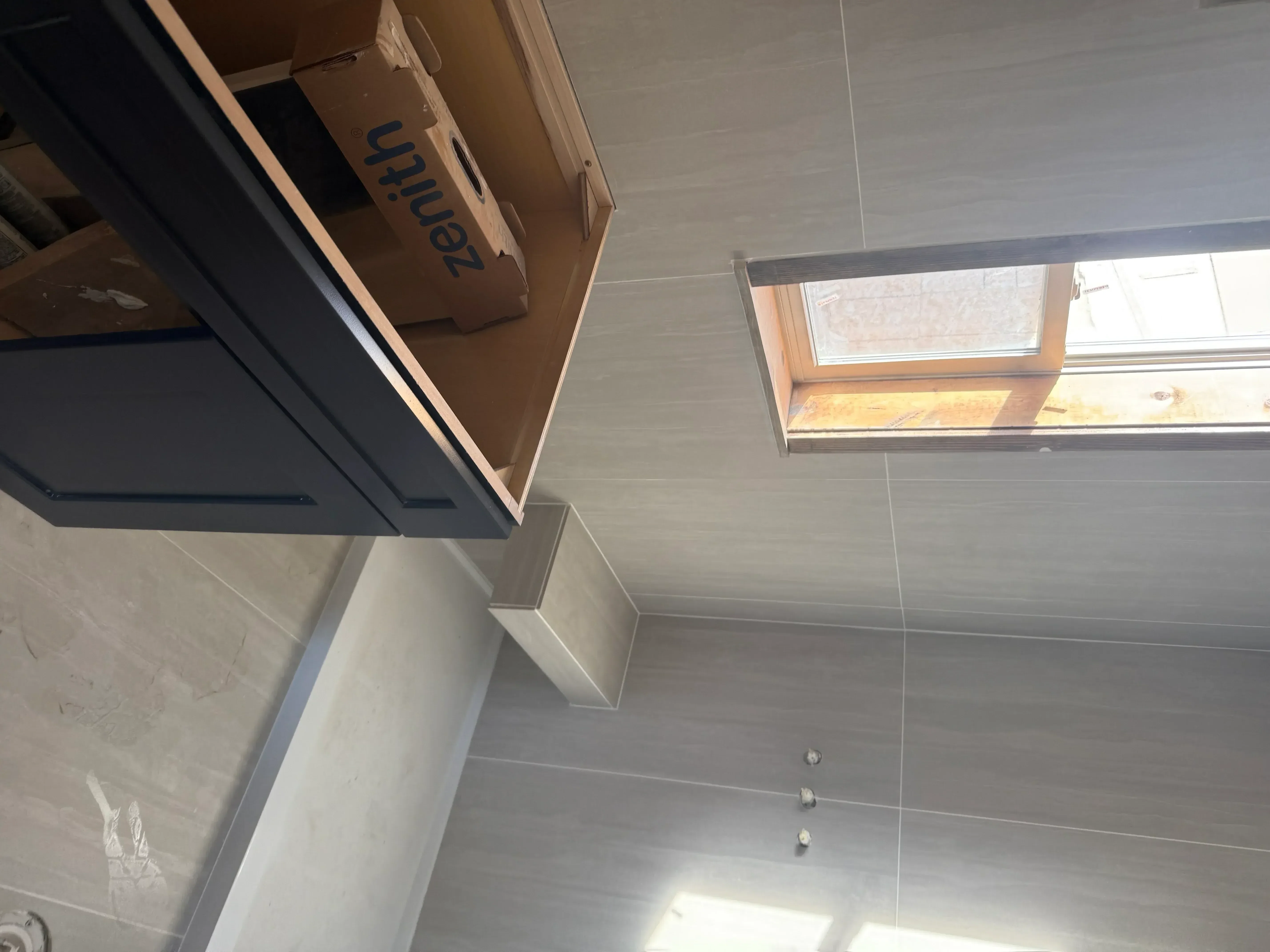 Gray ceramic tile bathroom with recessed lighting, built-in bench, and modern fixtures