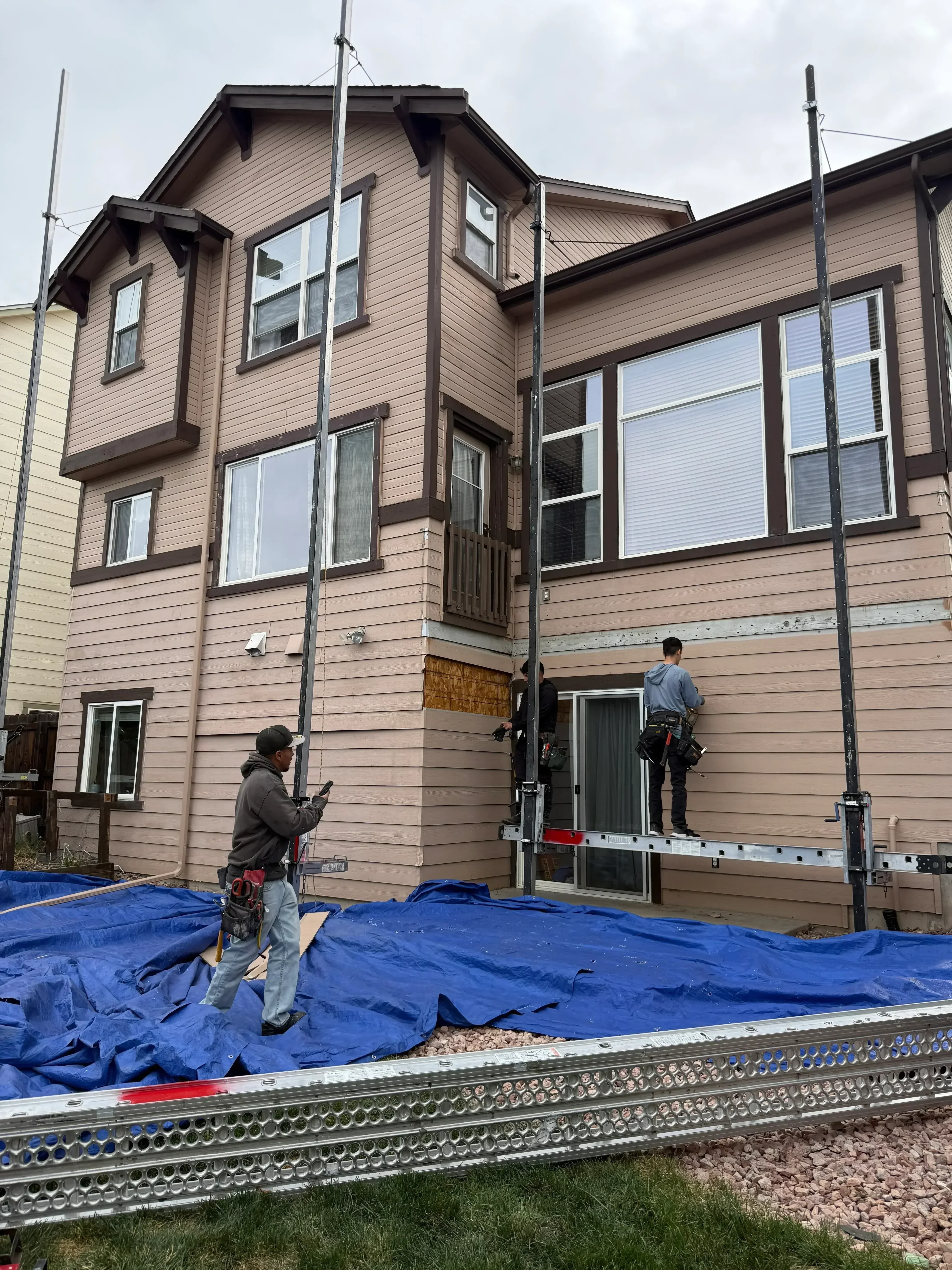 Brown metal siding with new windows installed on residential home exterior