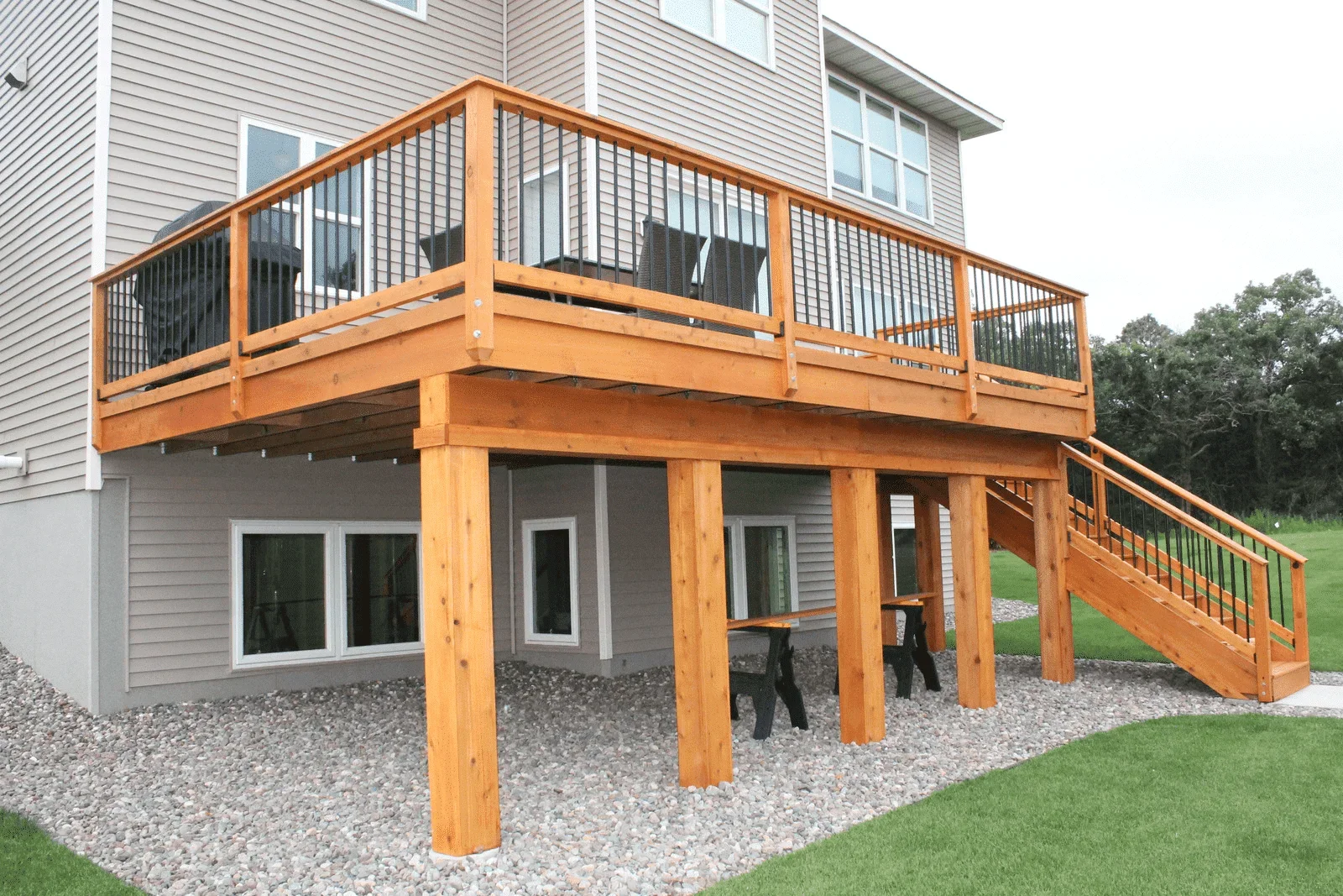 Two-level cedar deck with black cable railing, pressure-treated posts, and integrated stairs