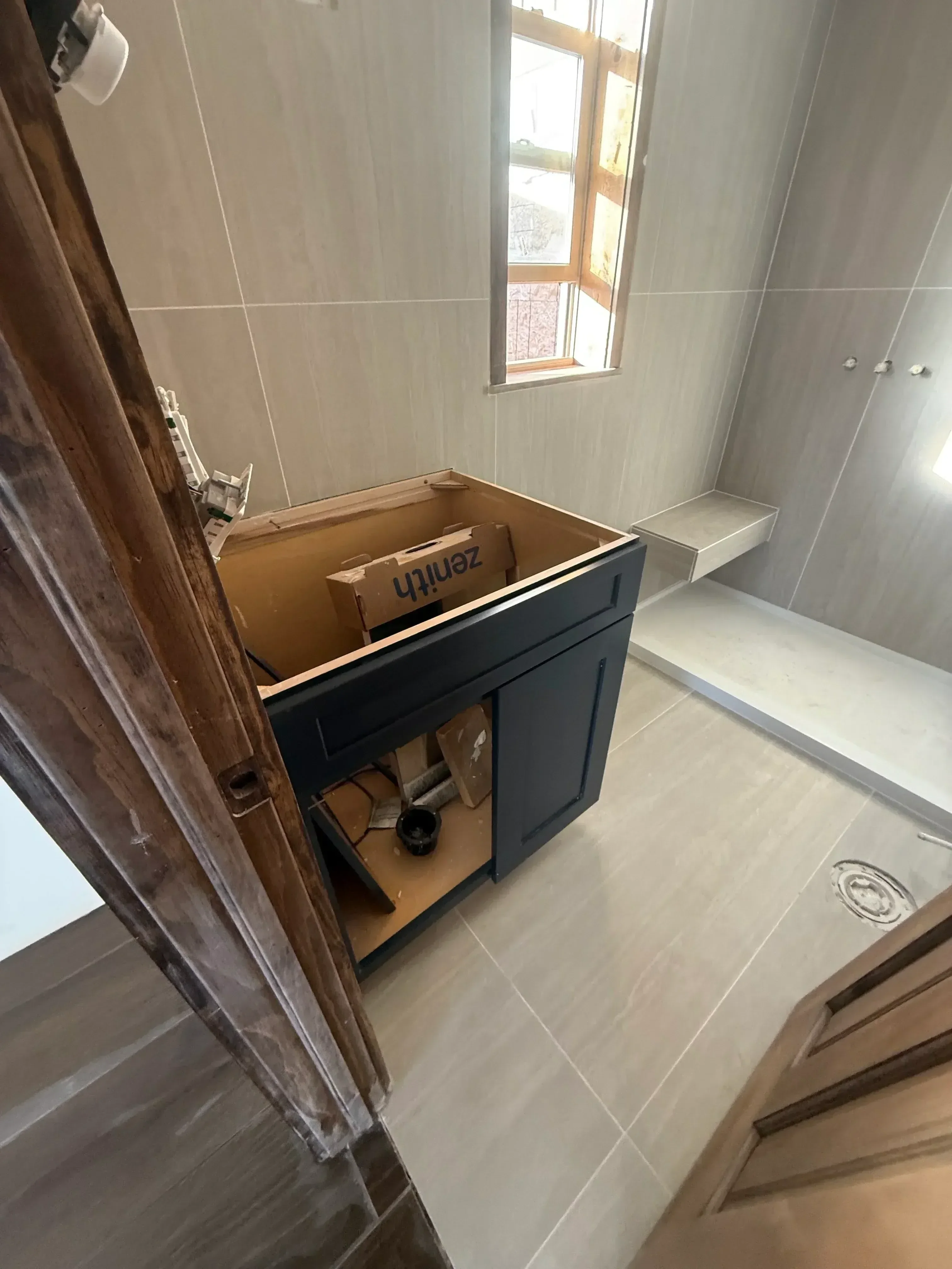 Gray ceramic tile bathroom walls with dark vanity cabinet and recessed lighting
