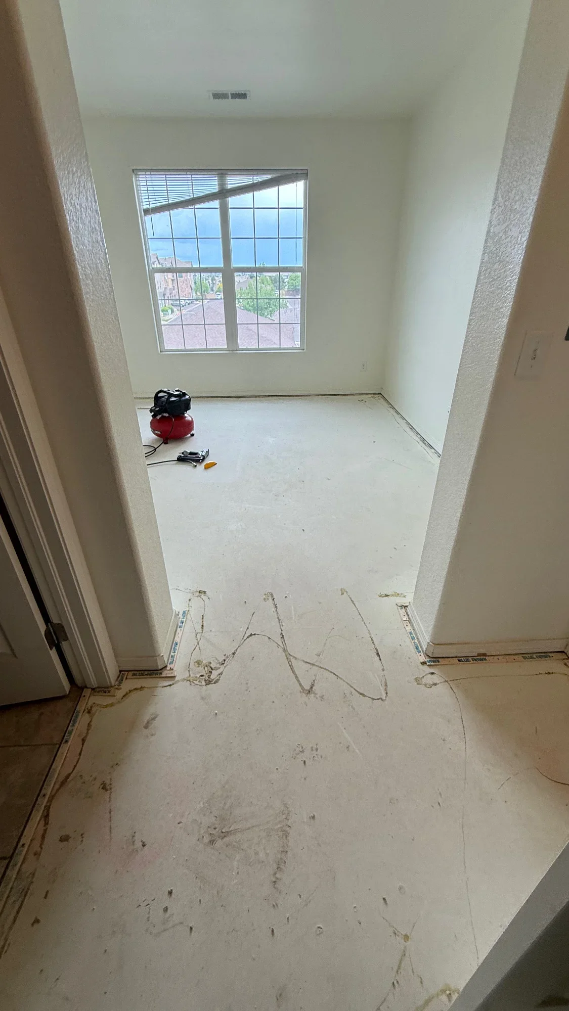 Kitchen space with drywall walls, large window, and electrical wiring during renovation prep