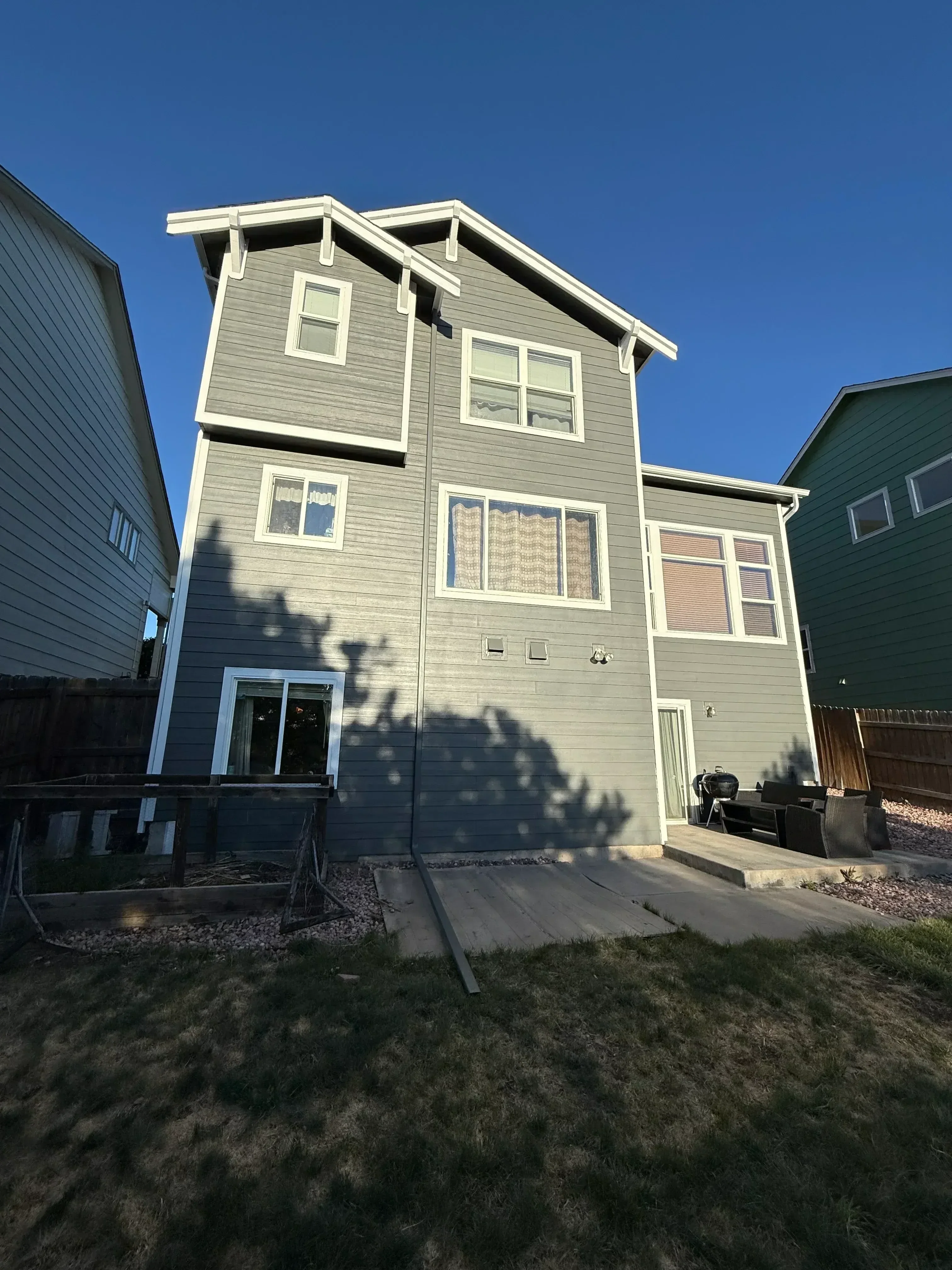 Metal siding exterior with white-trimmed windows and modern entry door installation